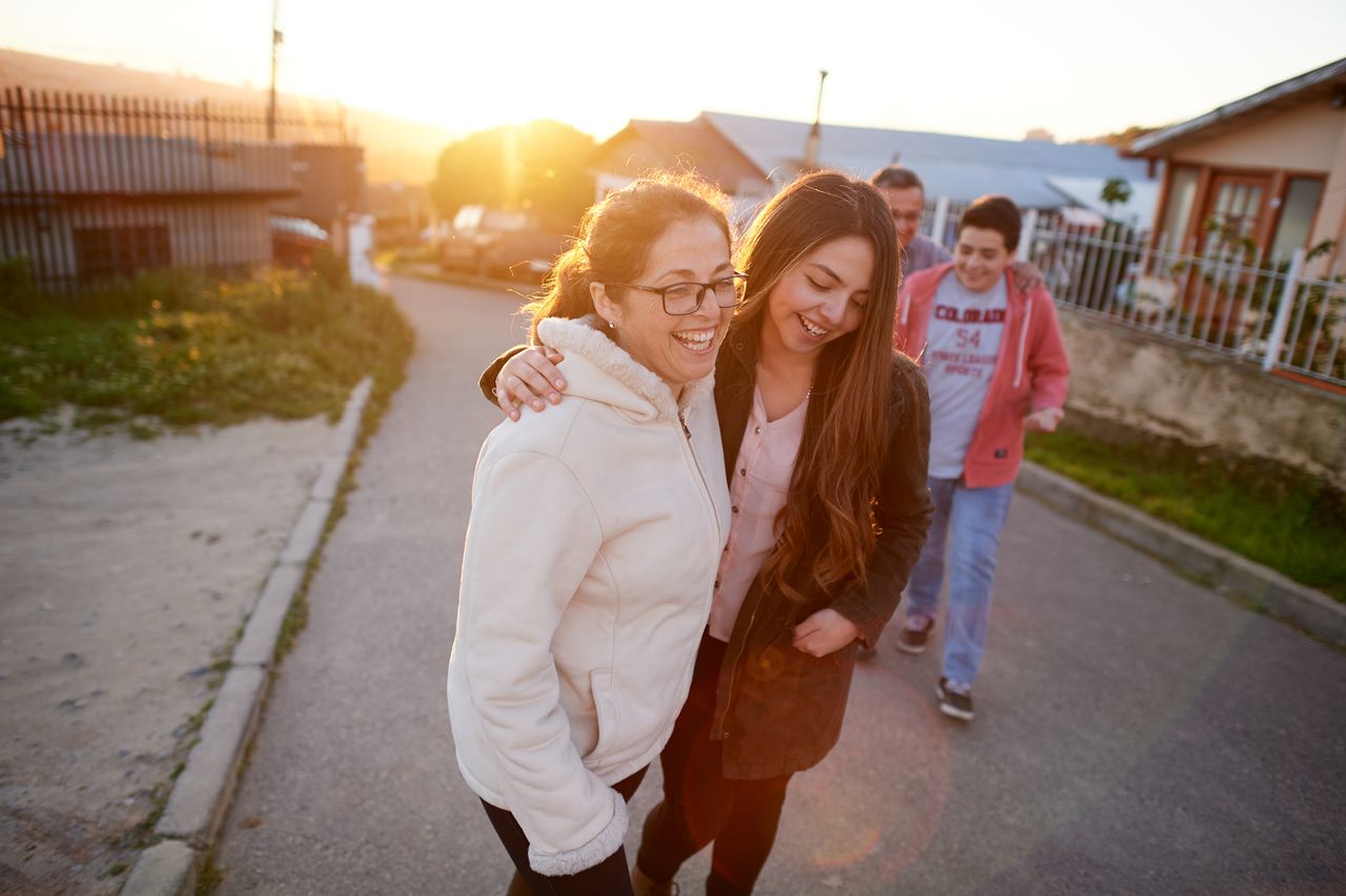 Une jeune famille marche sur un trottoir et profite du moment