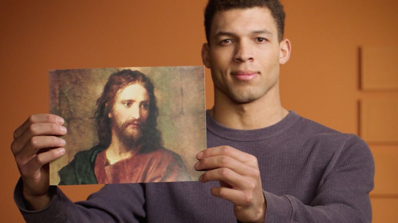 Homme tenant une image de Jésus-Christ