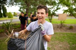 Un jeune homme avec un sac de feuilles