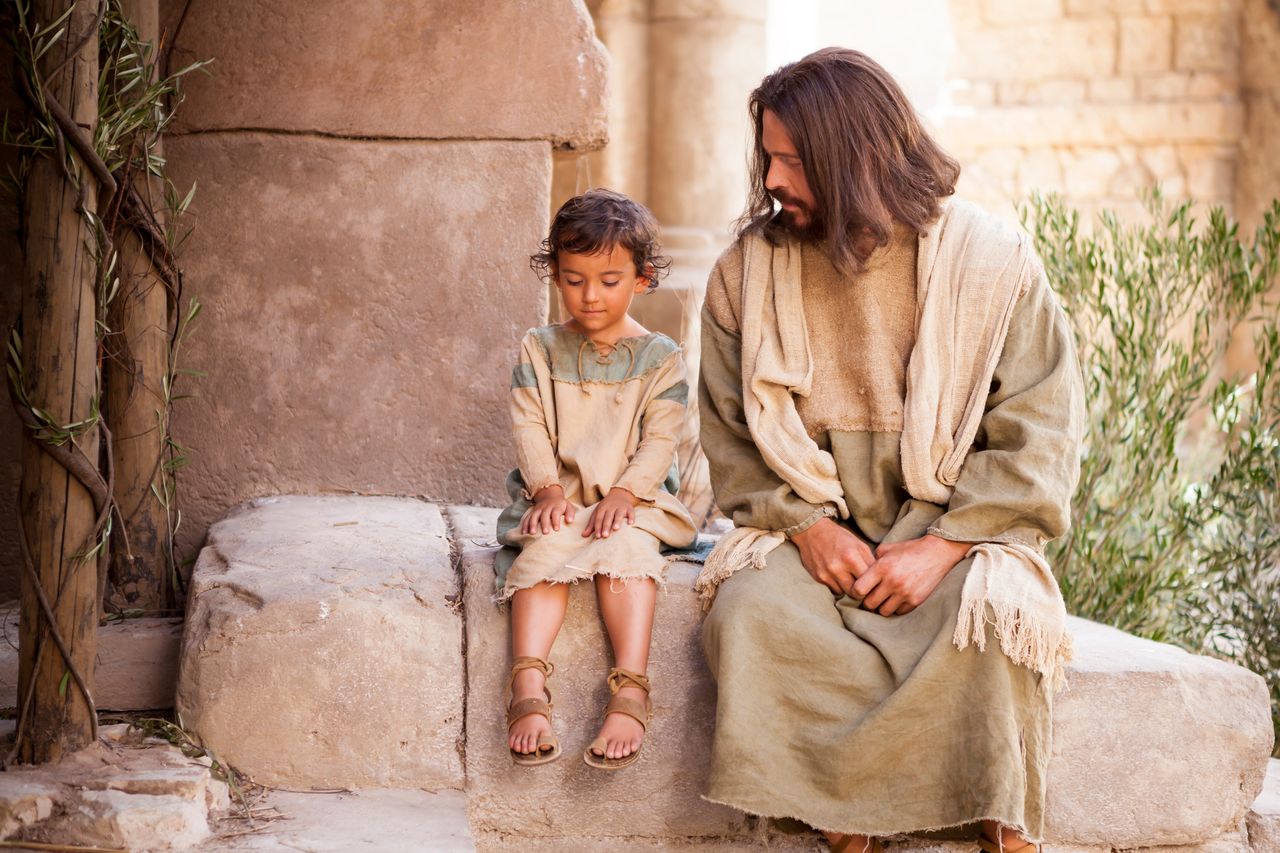 Jésus assis à côté d’un petit garçon