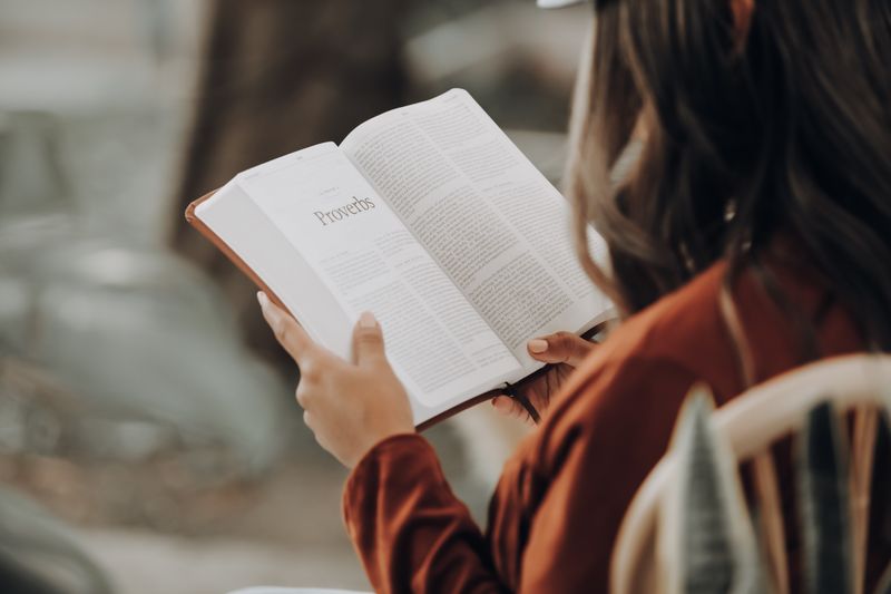 Une femme lit le livre des Proverbes dans la Bible