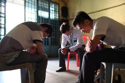 Un homme prie avec les missionnaires